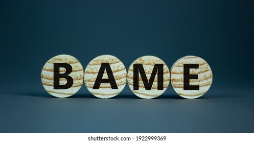 BAME Symbol. Abbreviation BAME, Black, Asian And Minority Ethnic On Wooden Circles. Beautiful Grey Background. Copy Space. Business And BAME, Black, Asian And Minority Ethnic Concept.