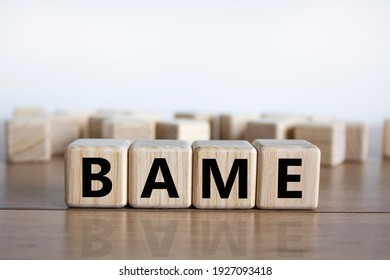 BAME Symbol. Abbreviation BAME, Black, Asian And Minority Ethnic On Wooden Cubes. Beautiful Wooden Table, White Background. Copy Space. Business And BAME, Black, Asian And Minority Ethnic Concept.