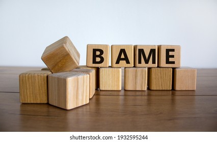 BAME symbol. Abbreviation BAME, black, asian and minority ethnic on wooden cubes. Beautiful wooden table, white background. Copy space. Business and BAME, black, asian and minority ethnic concept.