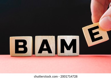 BAME symbol. Abbreviation BAME, black, Asian and minority ethnic on wooden cubes. Beautiful blue background. Copy space. Business and BAME, black, Asian and minority ethnic concept.