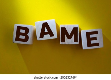 BAME symbol. Abbreviation BAME, black, Asian and minority ethnic on wooden cubes. Beautiful yellow background. Copy space. Business and BAME, black, Asian and minority ethnic concept.