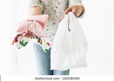 Ban single use plastic. Zero Waste shopping concept. Woman holding in one hand groceries in reusable eco bag and in other vegetables in plastic polyethylene bag. Choose plastic free items. - Shutterstock ID 1365584183