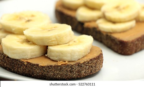 Banana And Almond Butter Toasts On White Plate