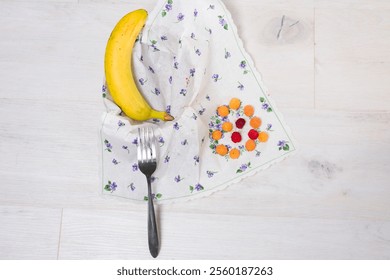 Banana, berries, and fork on floral napkin - Powered by Shutterstock