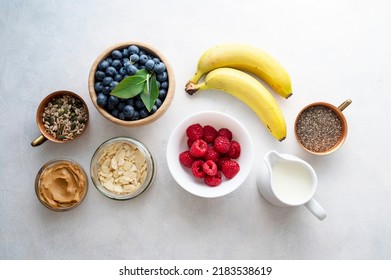 Banana And Berry Smoothie Ingredients Made From Fresh Banana, Blueberry, Raspberry, Milk, Peanut Butter, Chia Seeds, Almond Flakes.