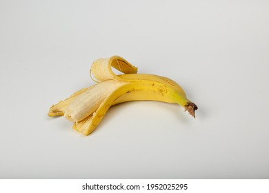 Banana bitten. A peeled and bitten banana in a peel on a white background. Old one peeled banana. Tropical yellow fruit. Selective focus. Bitten Banana.