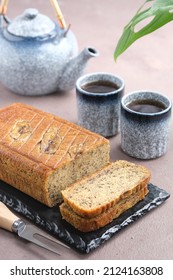 Banana Bread Or Banana Cake Serving On Black Plate With Mug And Teapot