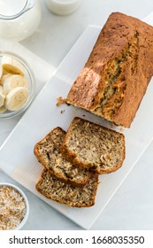 Banana bread with coconut and milk on a light gray background. Homemade delicious pastries. Top view, close- up, copy space.