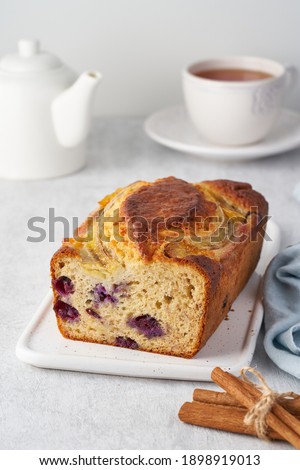 Banana bread, sliced cake with banana and blueberries. Morning breakfast with tea on light gray cincrete background, vertical Stock photo © 