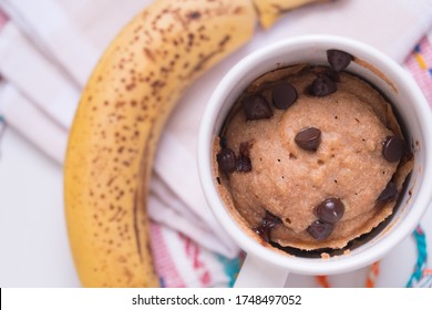 Banana Cake In Mug On Colors Rag With Chocolate Chips On White Marble