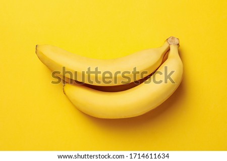 Banana cluster on yellow background. Fresh fruit