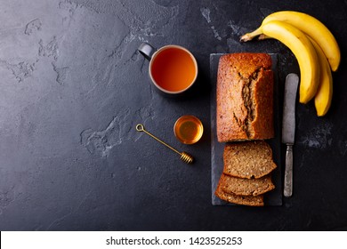 Banana, Coconut Bread, Cake With Cup Of Tea On Slate Board. Dark Stone Background. Copy Space. Top View.