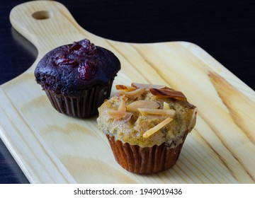 Banana Cupcake With Almond Toping And Chocolate Cherry Muffin On Wooden Board