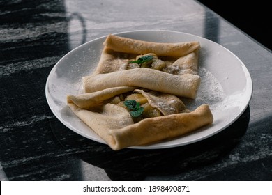 Crêpe With A Banana Filling And Mint Garnish