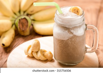 Banana Juice In Mug Glass On Wood Table