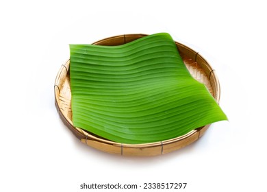 Banana leaves in bamboo weave plate on white background.