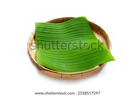 Banana leaves in bamboo weave plate on white background.
