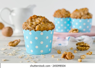 Banana muffins with oatmeal and walnuts on white table  - Powered by Shutterstock