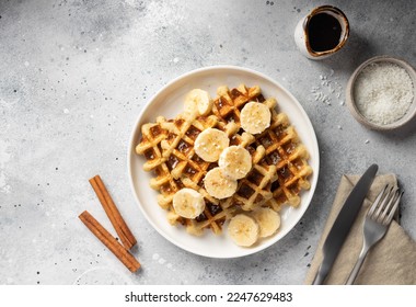 Banana oat waffles with cinnamon and coconut on white plate. homemade healthy breakfast. flat lay - Shutterstock ID 2247629483