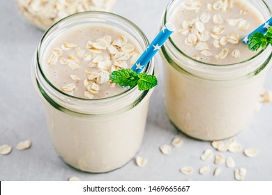 Banana Oats Smoothie Or Milkshake In Glass Mason Jars On A Gray Stone Background