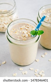 Banana Oats Smoothie Or Milkshake In Glass Mason Jars On A Gray Stone Background