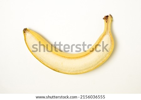 Banana on a white background. Half peeled banana. tropical fruit
