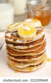 Banana Pancakes With Honey And Powdered Sugar On Plate, Closeup