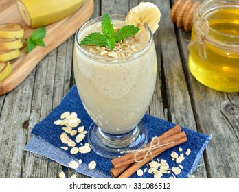 Banana Smoothie With Honey And Oats On A Wooden Table