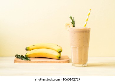 banana smoothies glass on wood table - Shutterstock ID 1060142729