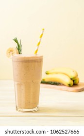 banana smoothies glass on wood table - Shutterstock ID 1062527666