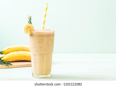 banana smoothies glass on wood table - Shutterstock ID 1101121082