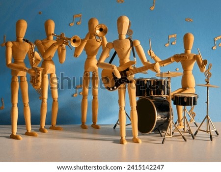 A band of 12 inch wooden drawing mannequin figures play trumpet, bass guitar, trombone, drums and saxophone against a blue backdrop with gold musical notes and treble and bass clefs