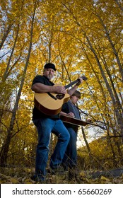 Band Members Play Bluegrass Music In The Woods.