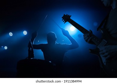Band Performing Live During Concert, Gig. Guitarist And Drummer Silhouettes