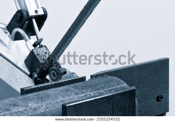 The \
band saw for industrial cutting  the metal rod and using the\
coolant in light blue scene. industrial tool\
concept