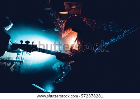 Band Silhouette. View of stage during rock concert with musical instruments and scene stage lights, rock show performance. Guitarist plays solo on stage. Electric guitar.