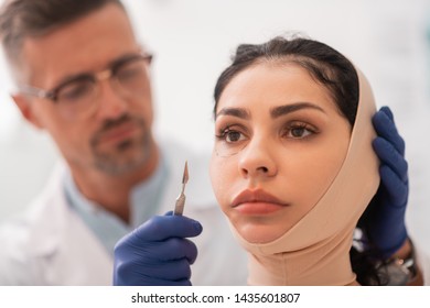 Bandage On Face. Dark-eyed Businesswoman Wearing Bandage On Face Before Plastic Surgery