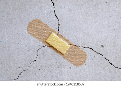 A bandage is stuck to a crack in the concrete wall. - Shutterstock ID 1940118589