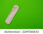 Band-aid isolated on green background. Top view of band aid with copy space.