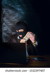 A Bandit In A Mask Of A Balaclava Using A Laptop Does Not Fair Profit On The Internet