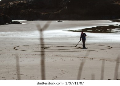 Bandon By The Sea, Oregon / USA - February 21 2020: Denny Dike, Founder Of Circles In The Sand Drawing A Walkable Labyrinth In The Flat Sandy Beach Of Face Rock State Park