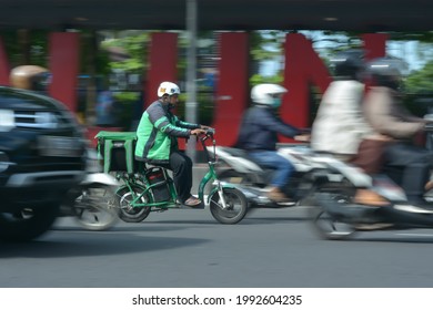 Bandung, Indonesia - 17 June 2021: Panning Photo Of Grab Driver Use Electric Bike To Deliver Consumer Order