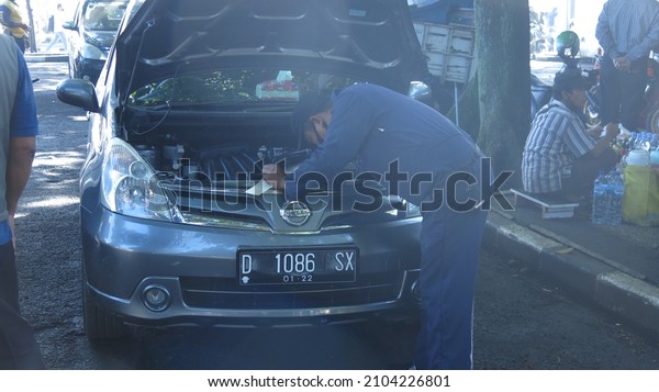 Bandung, Indonesia - January 8 2022 : Man in
uniform checking engine number for car registration in local DMV or
gesek rangka mesin di
samsat