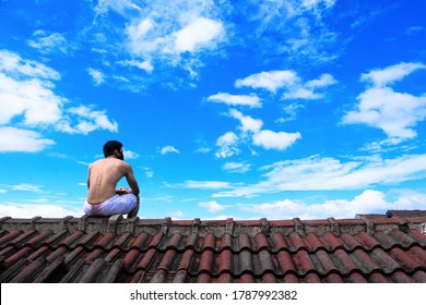 Bandung, Indonesia - July, 2020: A Man Wearing Mask Sun Bathing In The Roof Top Of The House As Daily Activity In New Normal Of Pandemic Covid-19. Its Become New Habit For Our Body Immunity.