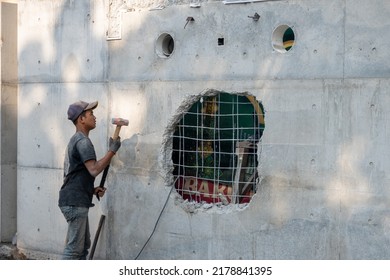 Bandung, Indonesia - June 29, 2022: Building Workers Tear Down Building Walls Using Large Hammers.