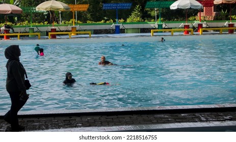 Bandung, Indonesia-October 2022: Asian Female Swimming Coach Teaching Students To Swim In A Swimming Pool In Bandung, Indonesia