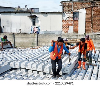 Bandung, West Java Indonesia, June 4, 2022 : A Group Of Workers, Work Together To Lift A Concrete Block For A Railroad Track