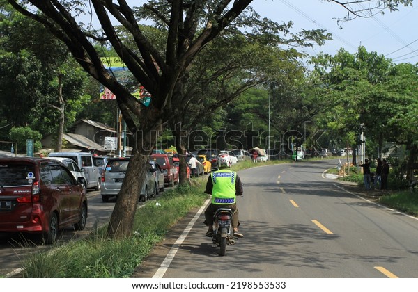 Bandung, West Java, Indonesia - June 8, 2019 : A\
motorcycle trying to go against the road during a long traffic jam\
on the Soreang road to the Ciwidey tourist area, during the long\
holiday season.