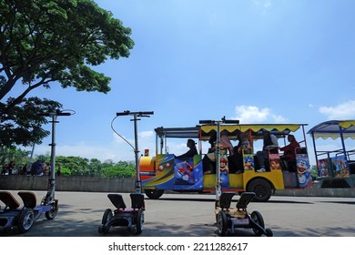 Bandung, West Java Indonesia, September 25, 2022 : Tourist Vehicle, Three Driverless Scooters With A Tourist Train Slow Motion Background