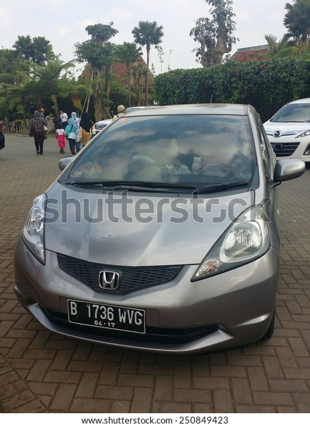 BANDUNG, WEST JAVA, INDONESIA- SEPTEMBER 15, 2014\
: Honda Jazz parked in front of a popular tourist attraction\
location in Bandung, Indonesia. Honda Jazz also known as Honda Fit\
in Japan.